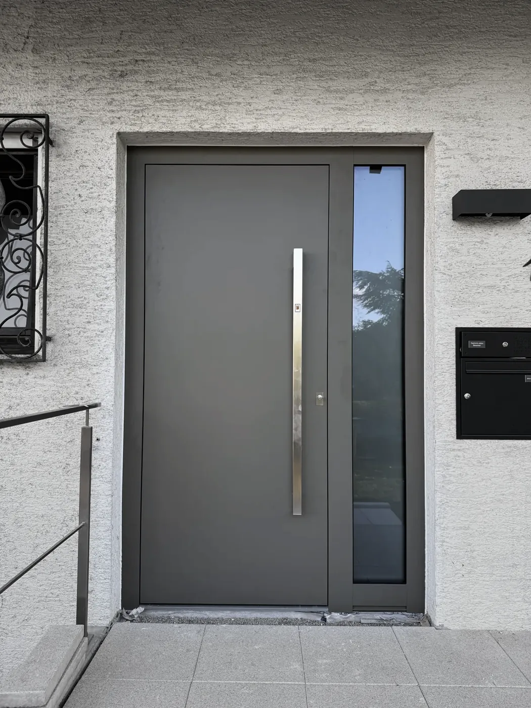 Graue Tür mit Glas-Seitenteil rechts