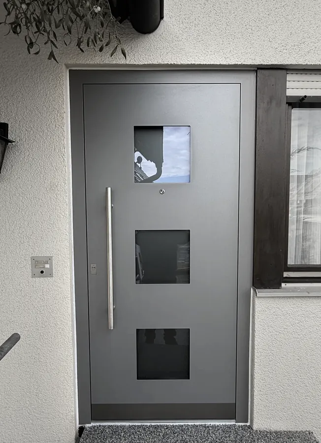 Graue Tür mit drei Glasquadraten