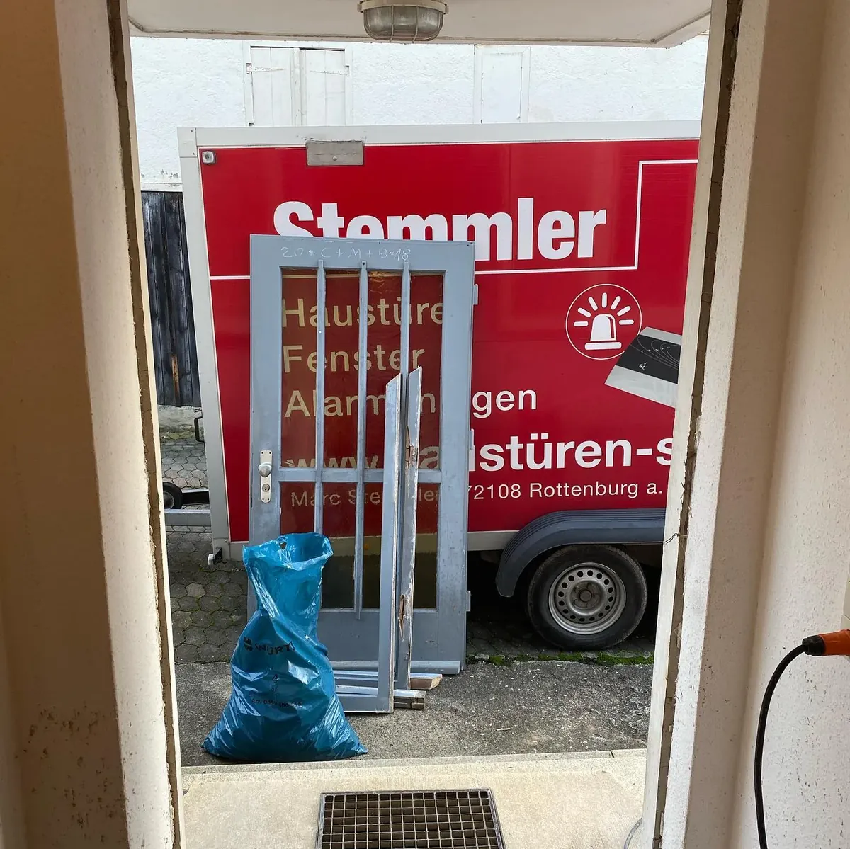Die alte Tür steht zum Abtransport am Stemmler-Anhänger bereit