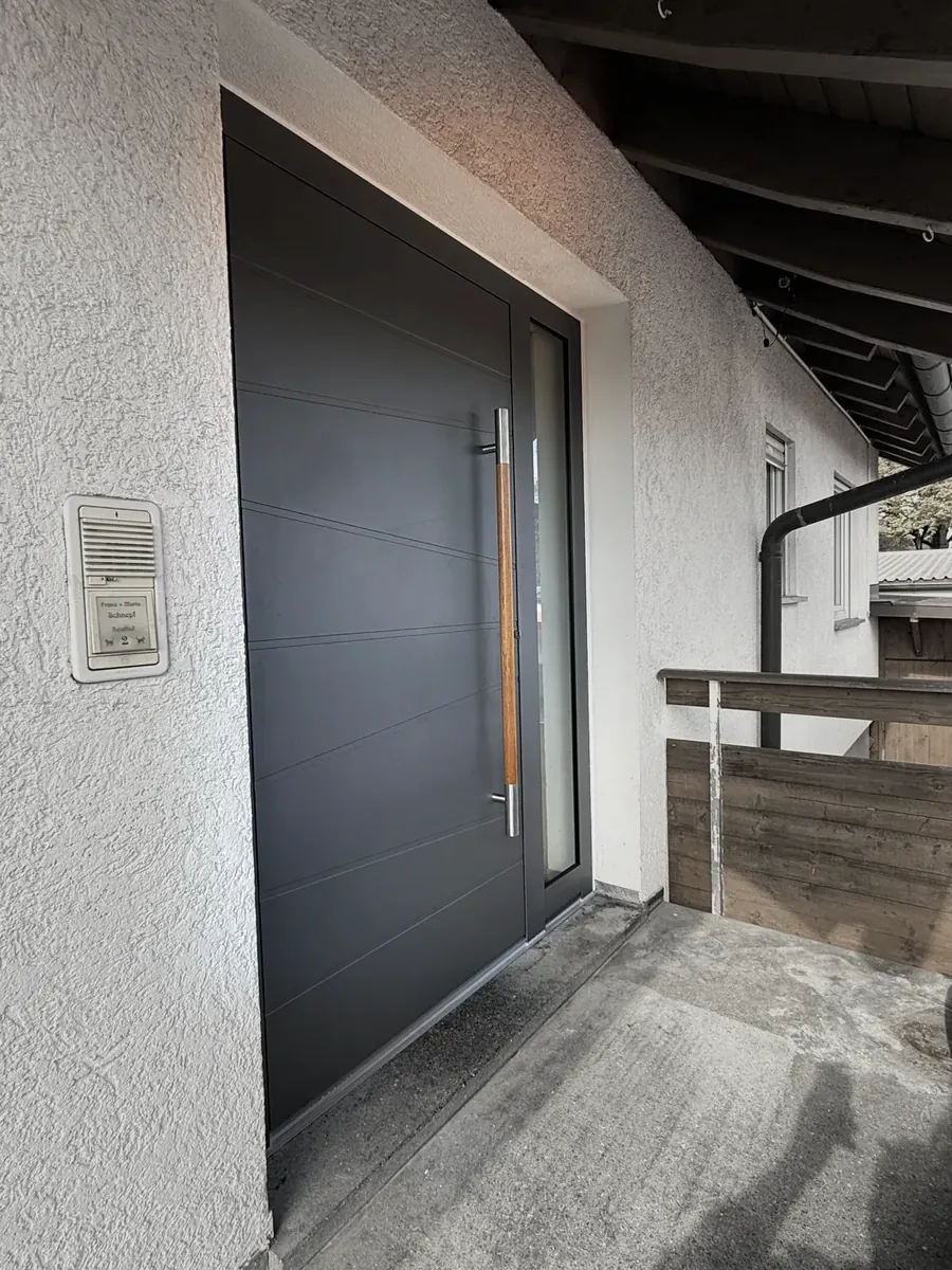 Anthrazitfarbene Haustür mit Griffleiste in Holzoptik