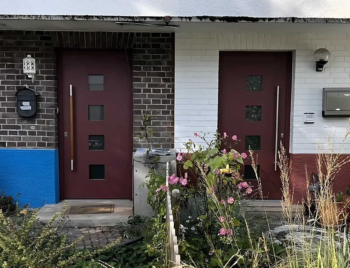 Doppelhaus mit zwei neuen roten Haustüren, von uns eingebaut
